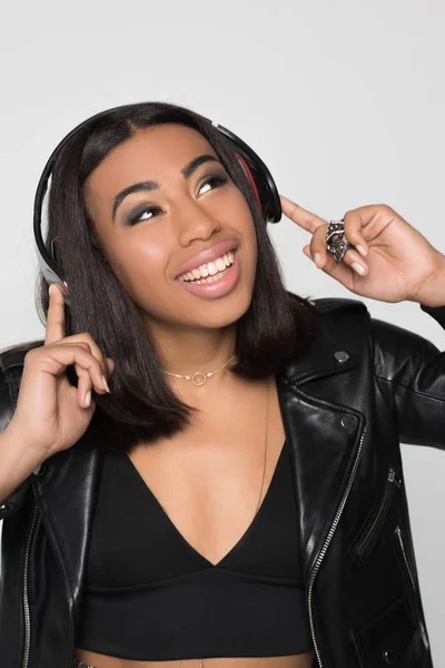 Sorrindo jovem mulher tocando fones de ouvido — Fotografia de Stock