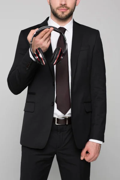 Joven empresario sosteniendo auriculares en las manos — Stock Photo