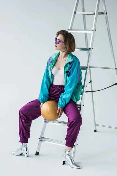 Mujer elegante apoyada en la escalera - foto de stock