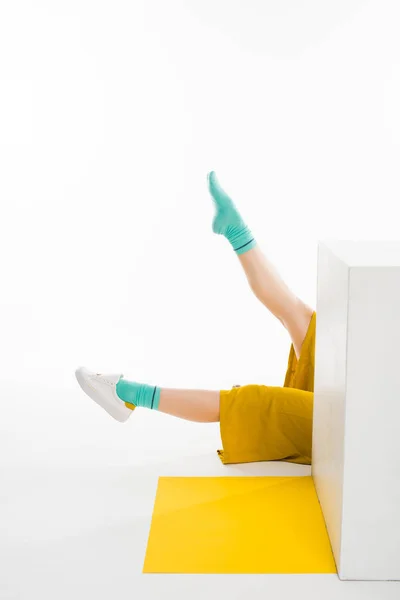 Piernas femeninas detrás del cubo blanco - foto de stock