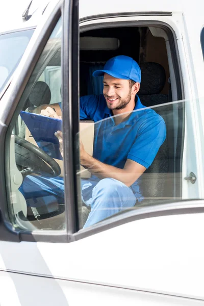 Delivery man filling in documents — Stock Photo