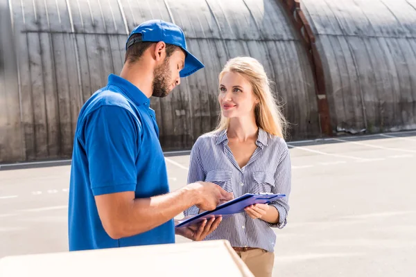 Woman signing delivery document — Stock Photo