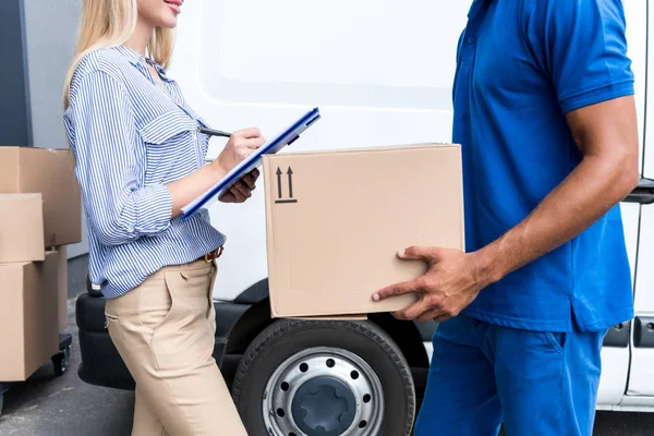 Courier delivering packages for woman — Stock Photo
