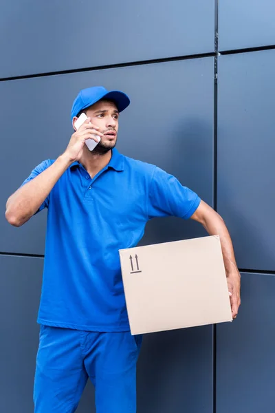 Delivery man talking by phone — Stock Photo