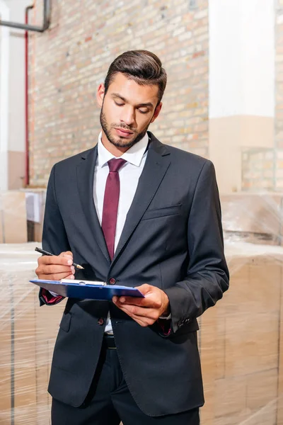 Businessman writing on clipboard — Stock Photo
