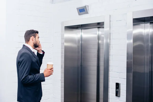 Businessman talking by phone with coffee — Stock Photo