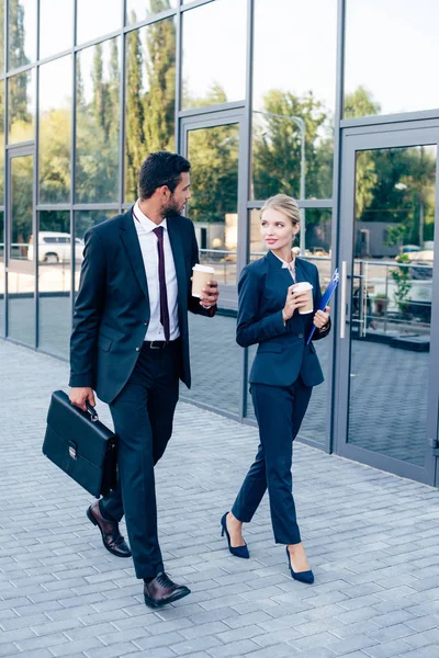 Businesspeople walking with coffee — Stock Photo