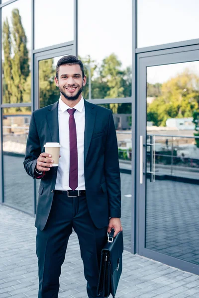 Бизнесмен с портфелем и кофе — стоковое фото