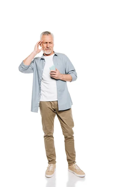 Mann mit Kopfschmerzen hält Smartphone in der Hand — Stockfoto