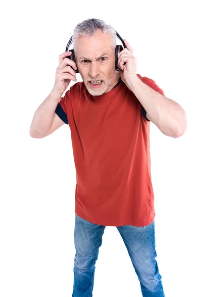 Irritado homem idoso em grandes fones de ouvido — Fotografia de Stock