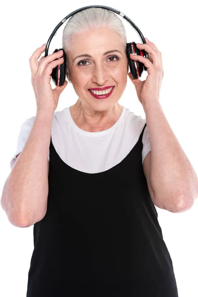 Mujer mayor en auriculares grandes - foto de stock