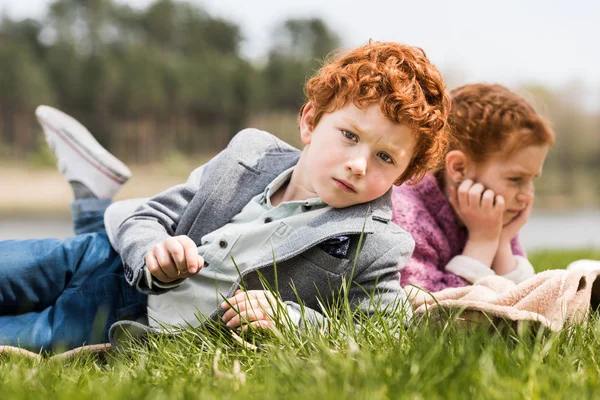 Geschwister liegen im Gras — Stockfoto