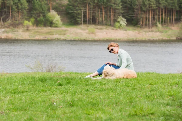 Donna con cane sull'erba — Foto stock