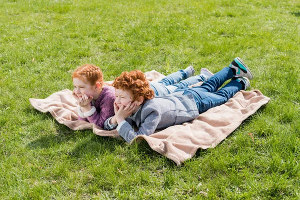 Geschwister liegen im Gras — Stockfoto