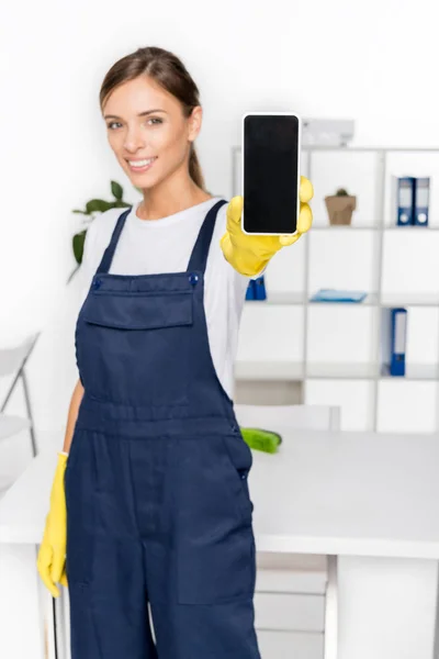 Jeune femme de ménage avec smartphone — Photo de stock