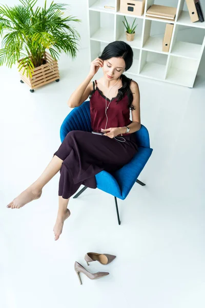 Mujer de negocios en auriculares con smartphone - foto de stock