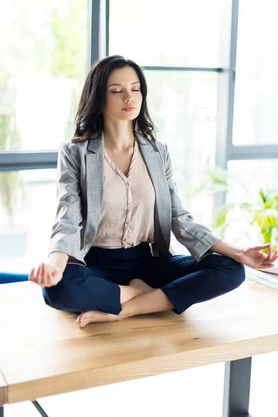 Businesswoman meditating at workplace — Stock Photo