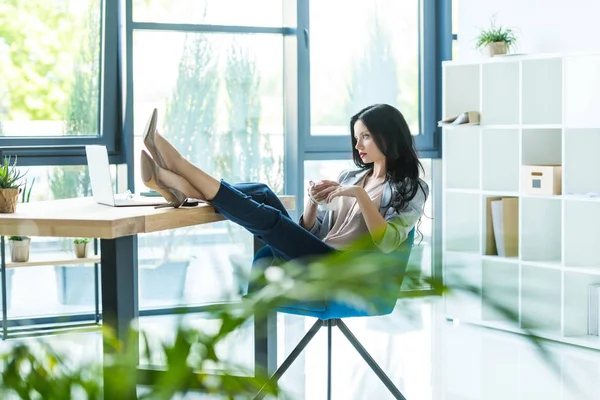 Femme d'affaires sur le lieu de travail avec ordinateur portable — Photo de stock