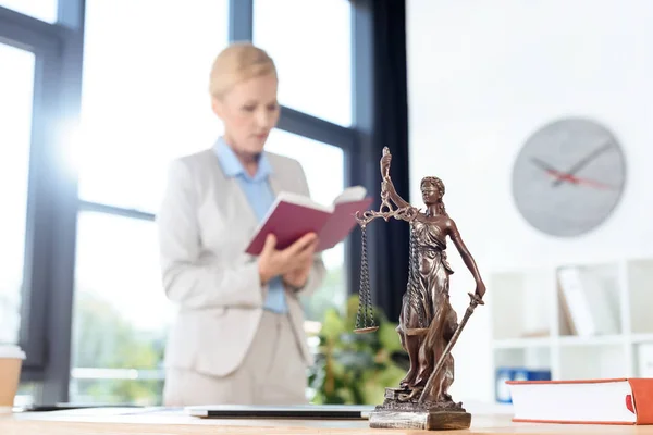 Female lawyer reading book — Stock Photo