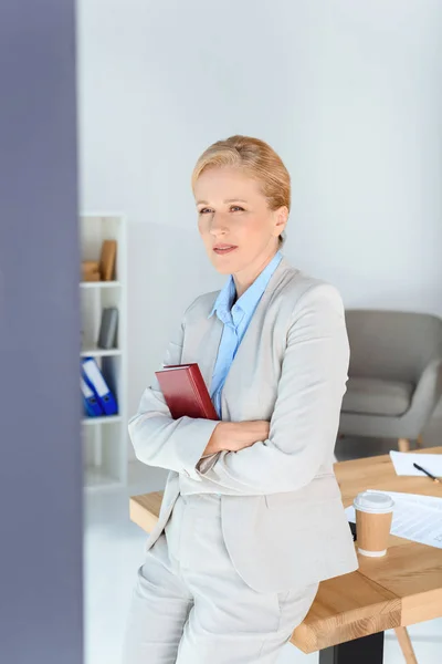 Donna d'affari matura con libro — Foto stock