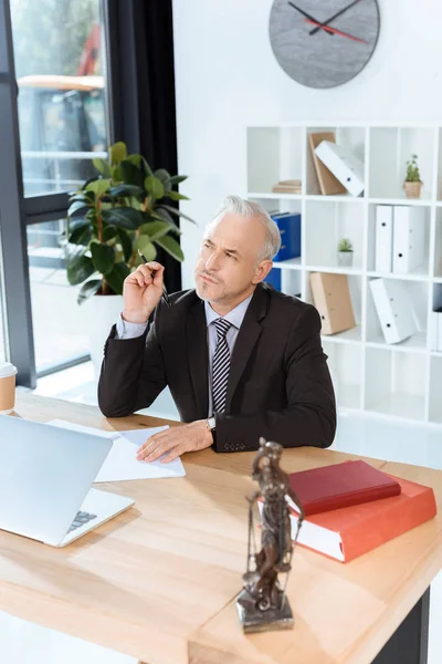 Reifer Anwalt sitzt am Arbeitsplatz — Stockfoto