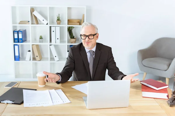 Homem de negócios com papelada e laptop — Fotografia de Stock