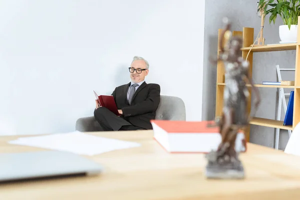 Avocat livre de lecture dans le fauteuil — Photo de stock