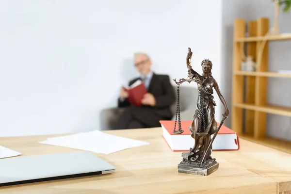Avvocato sul posto di lavoro con statua themis — Foto stock