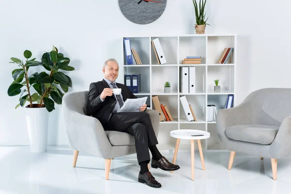 Uomo d'affari in poltrona bere caffè — Stock Photo