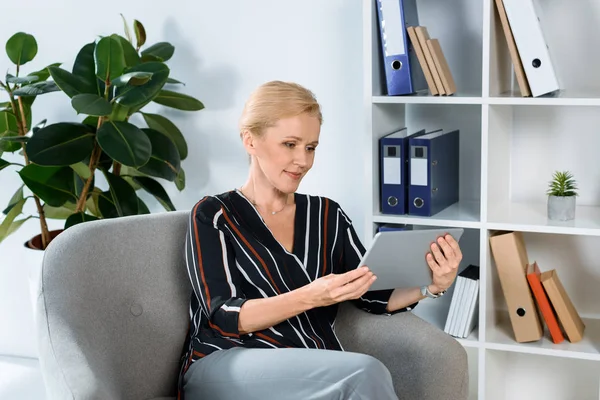 Mujer de negocios mirando tableta en la oficina - foto de stock