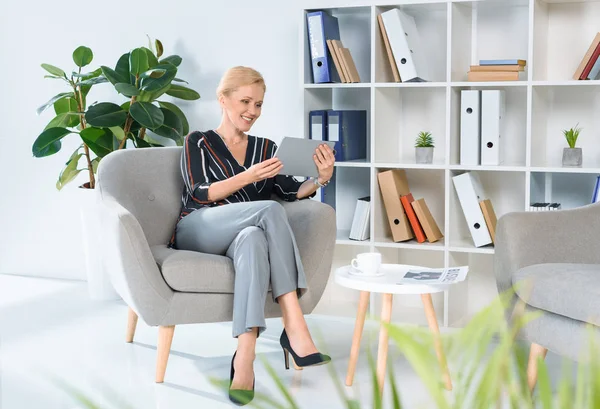 Geschäftsfrau schaut im Büro auf Tablet — Stockfoto