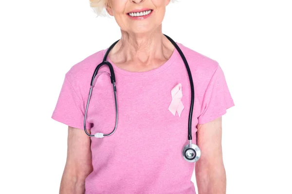Пожилая женщина с розовой лентой и стетоскопом — стоковое фото