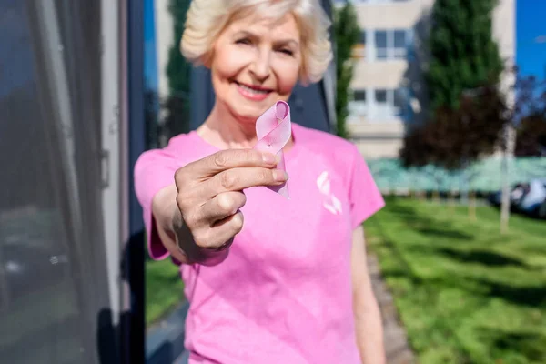 Mujer mayor con cinta rosa - foto de stock
