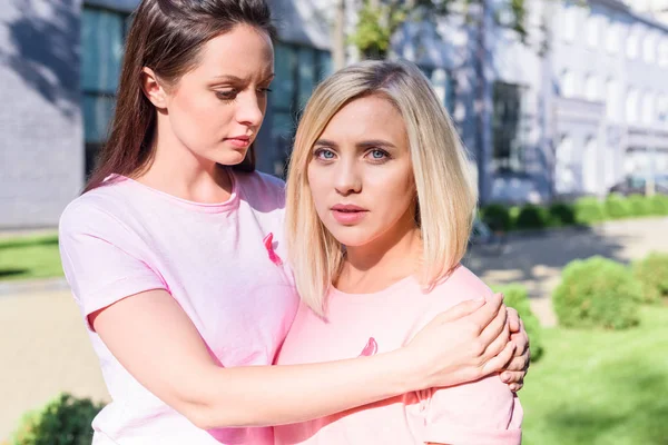 Mulheres em camisetas rosa abraçando — Fotografia de Stock