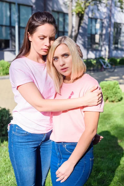 Mulheres em camisetas rosa abraçando — Fotografia de Stock