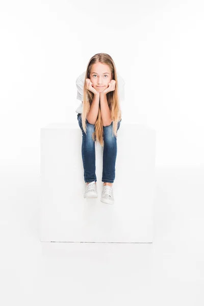 Enfant assis sur un cube blanc — Photo de stock