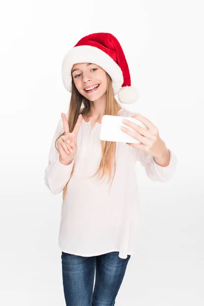 Adolescente in cappello di Babbo Natale prendendo selfie — Foto stock