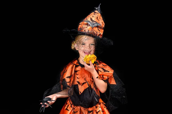 Pequeña bruja comiendo calabaza - foto de stock