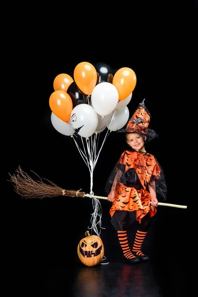 Pequeña bruja con escoba y globos - foto de stock