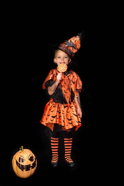 Little witch eating lollipop — Stock Photo