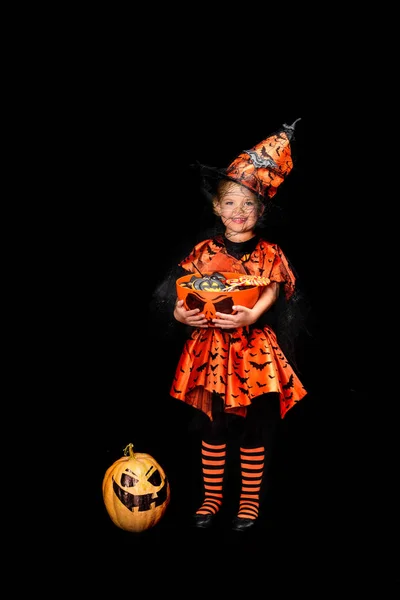 Pequena bruxa com doces de Halloween — Fotografia de Stock