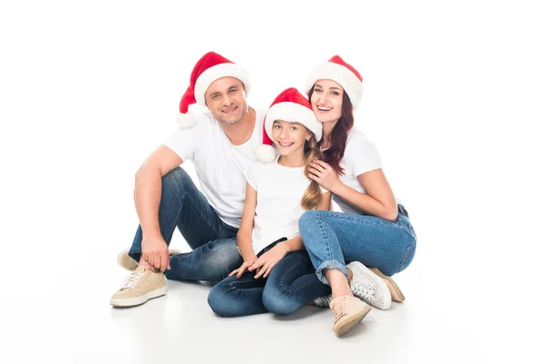 Lächelnde Familie mit Weihnachtsmann-Hüten — Stockfoto