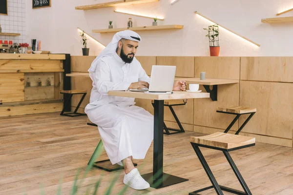 Hombre musulmán usando el ordenador portátil - foto de stock