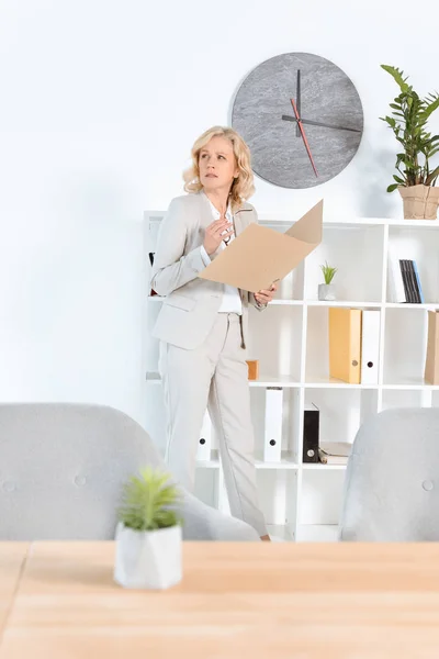 Деловая женщина с папкой в офисе — стоковое фото
