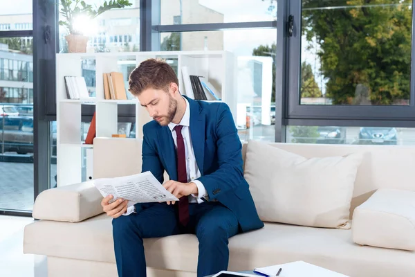 Businessman reading newspaper — Stock Photo