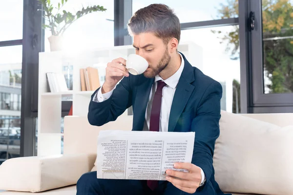 Geschäftsmann mit Zeitung trinkt Kaffee — Stockfoto