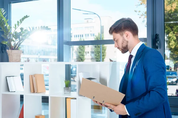 Empresario sosteniendo carpeta - foto de stock