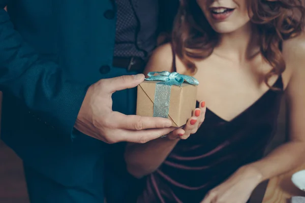 Homme présentant cadeau à petite amie — Photo de stock