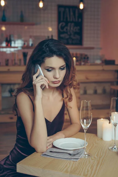 Woman talking on smartphone in restaurant — Stock Photo