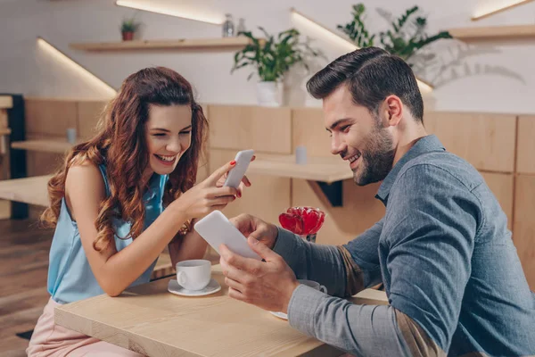 Pareja con smartphones en la cafetería - foto de stock